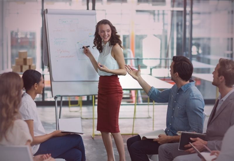 Mulher líder inspirando equipe com postura firme, empatia e comunicação assertiva no ambiente corporativo
