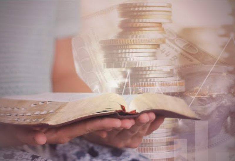 Mulher refletindo com uma bíblia e algumas contas sobre a mesa, simbolizando fé e finanças.
