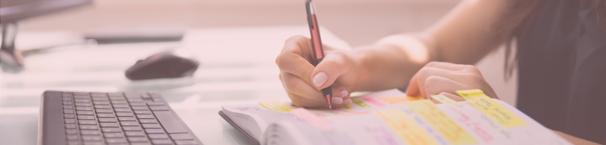 Mão feminina usando notebook e agenda representando contato com mentoria estratégica para mulheres