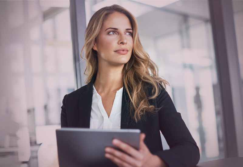 Mulher profissional sozinha em ambiente corporativo, refletindo sobre maturidade, autonomia e prontidão para sociedade nos negócios.