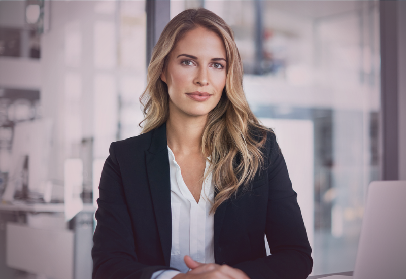 Mulher em ambiente corporativo com postura firme e expressão serena, representando liderança consciente e os limites da responsabilidade na comunicação profissional.