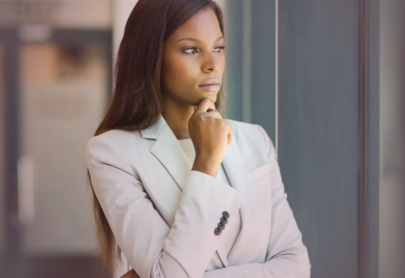 Mulher em ambiente corporativo refletindo sobre maturidade emocional, prontidão financeira e responsabilidade nas decisões pessoais e profissionais.