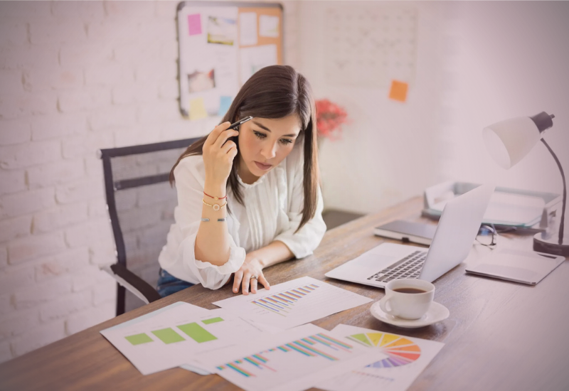 mulher analisando dados financeiros e refletindo sobre organização e prosperidade