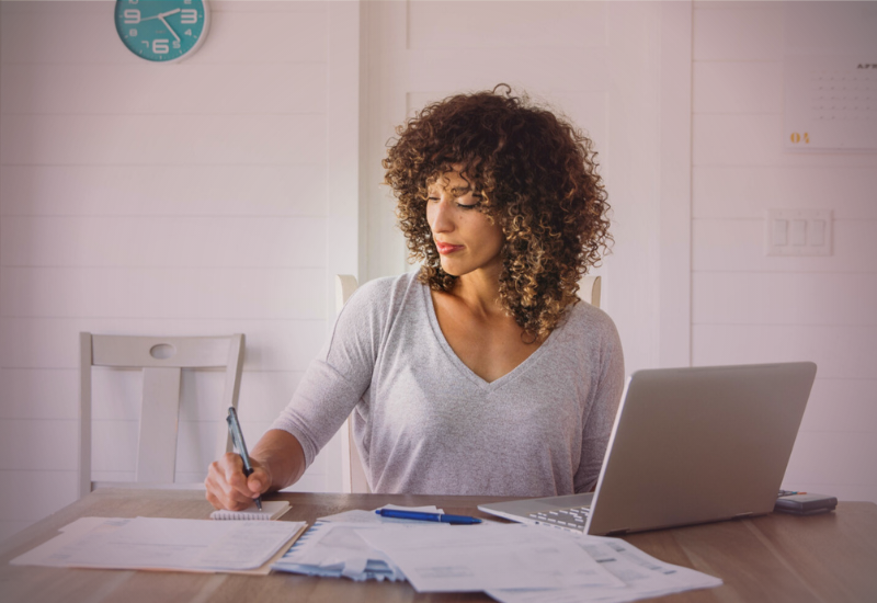 Mulher organizando suas finanças em casa com rotina de controle e planejamento financeiro