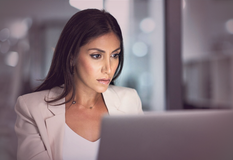 Mulher líder concentrada analisando informações no notebook, representando o peso emocional das decisões na liderança